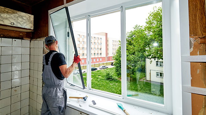 Handwerker tauscht die Verglasung an einem Fenster aus