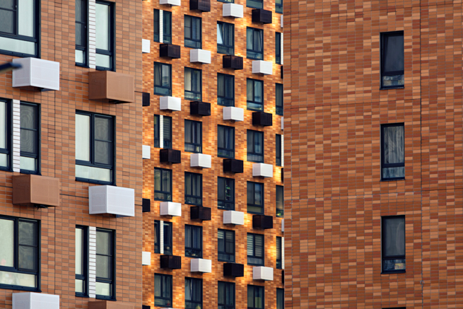 Große Hausfassade mit vielen verschiedenen Fenstern in weiss und anthrazit