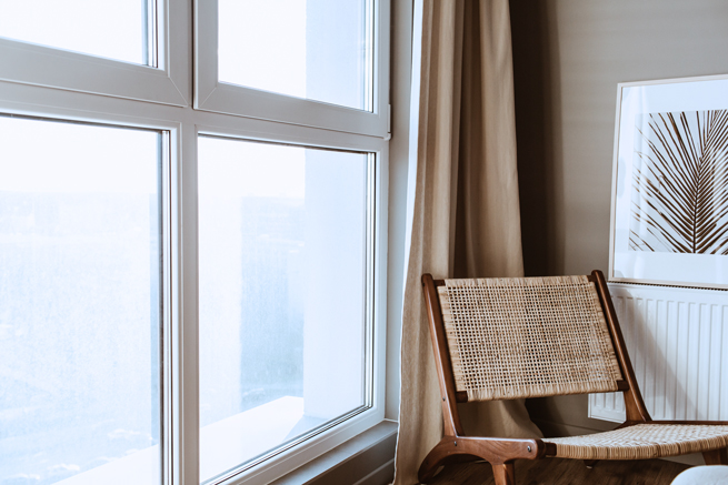 Stuhl vor einem Fenster mit zwei Flügeln und zwei Teilen Festverglasung