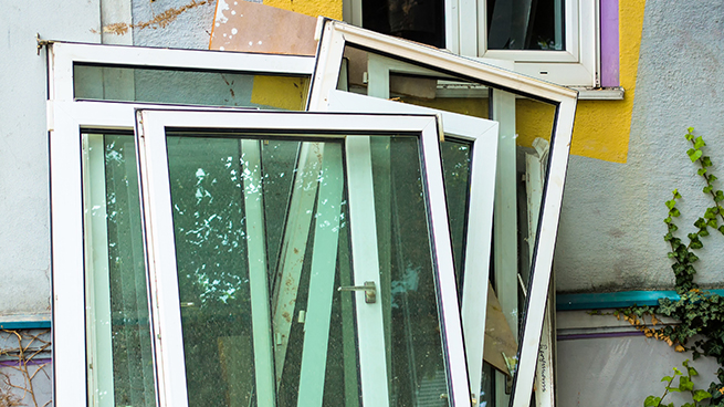 Alte und kaputte Fenster nach dem Fensteraustausch unter einem neu eingebauten Fenster