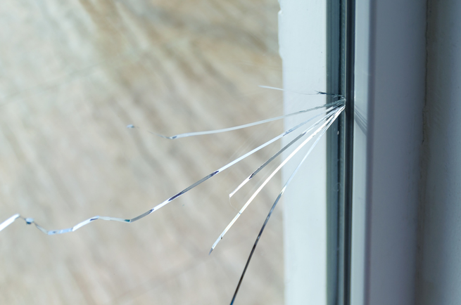 Mehrere Risse in einer Glasscheibe in einem Kunststofffenster