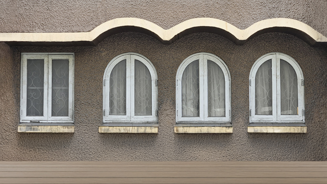 Rundbogenfenster und normales Fenster nebeneinander in einer Hausfassade
