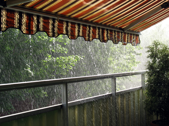 Gestreifte Markise als Regenschutz in einem Regenschauer