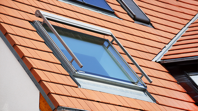 Protection solaire au-dessus d'une fenêtre de toit avec store à caisson