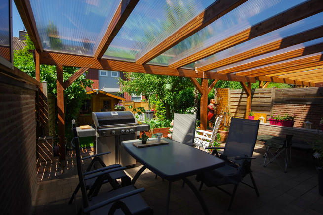 Gemütliche Terrasse mit Acrylglas als Material für das Dach mit vielen Pflanzen