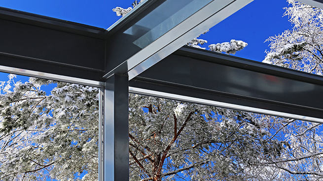 Abri de terrasse en aluminium photographié de l'intérieur avec véranda à l'extérieur