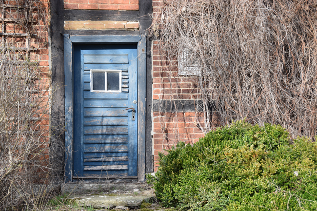 Alte Haustür mit abgeplatzter blauer Farbe