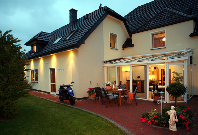 Aussenansicht Haus mit Wintergarten am Abend mit Beleuchtung