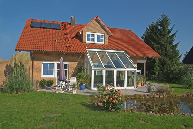 Aussenansicht Haus mit weißem Wintergarten