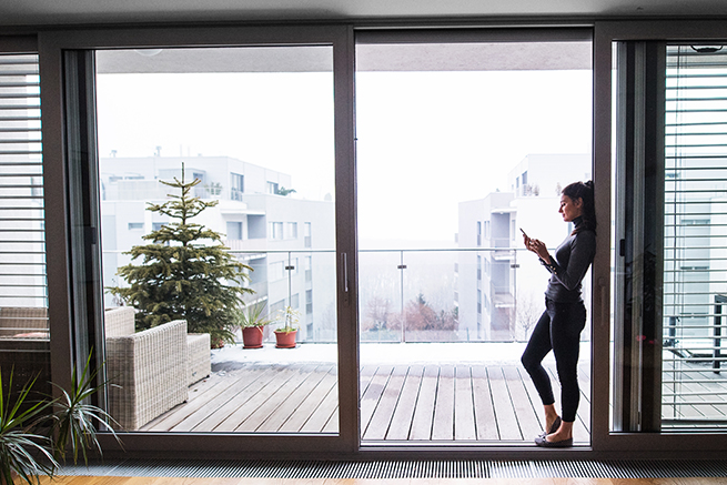 Vue à travers une porte-fenêtre en bois et aluminium sur le panorama urbain
