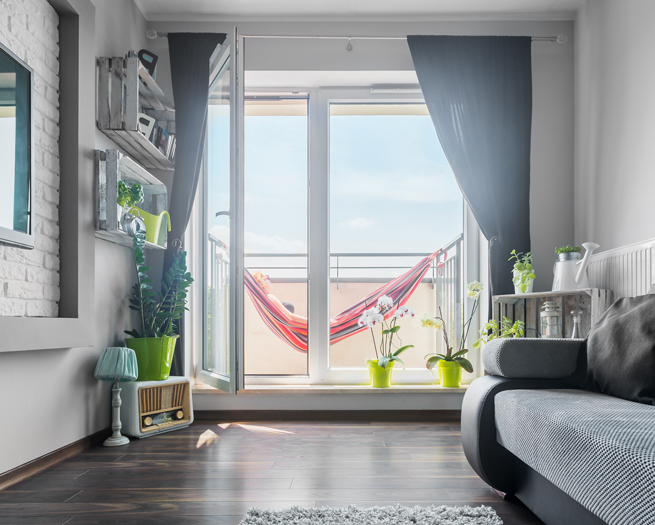 Une porte-fenêtre mène à un balcon avec hamac
