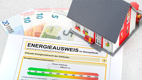 Symbolbild Haus mit Energieausweis und Geldscheinen