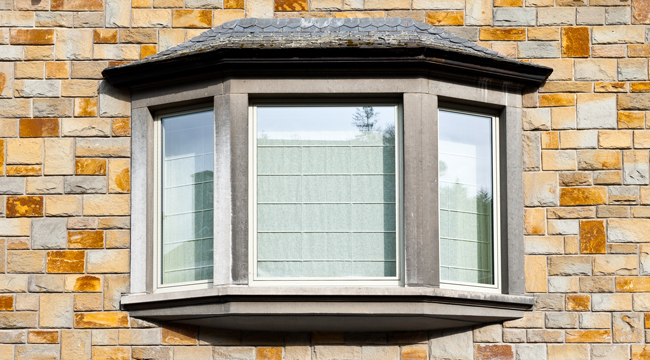 Weiße Erkerfenster in Steinfassade