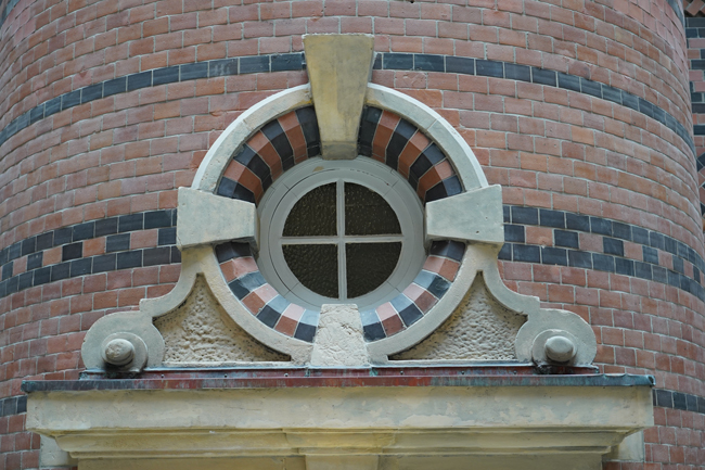 Kleines rundes Fenster mit Sprossen und Ornamentverglasung