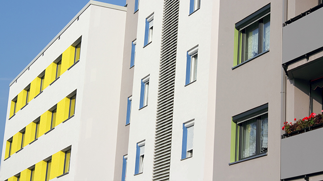 Hausfront mit verschiedenen Fenstergrößen und Farbigen Fensterrahmen