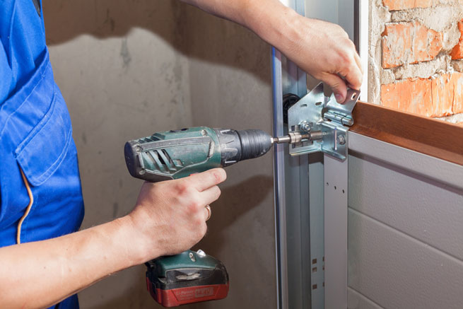 Handwerker befestigt Garagentor