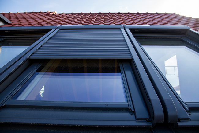 Dachfenster mit halb heruntergelassenem Rollladen
