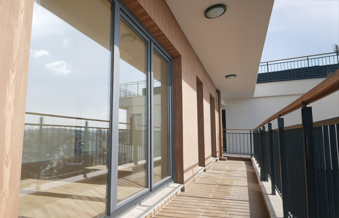 Baie oscillo-coulissante en aluminium  avec revêtement gris avec balcon et garde-corps