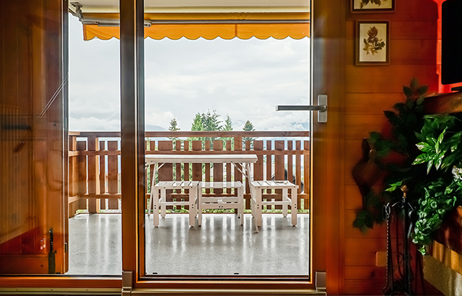 Baie oscillo-coulissante en bois avec vue sur le balcon