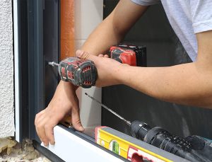 Un artisan installe une fenêtre