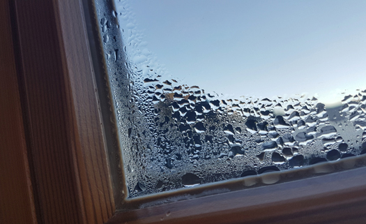 Une fenêtre est embuée de l'intérieur avec formation de condensation