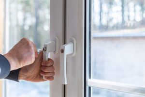 Une poignée verrouillable est fermée sur une fenêtre en PVC.