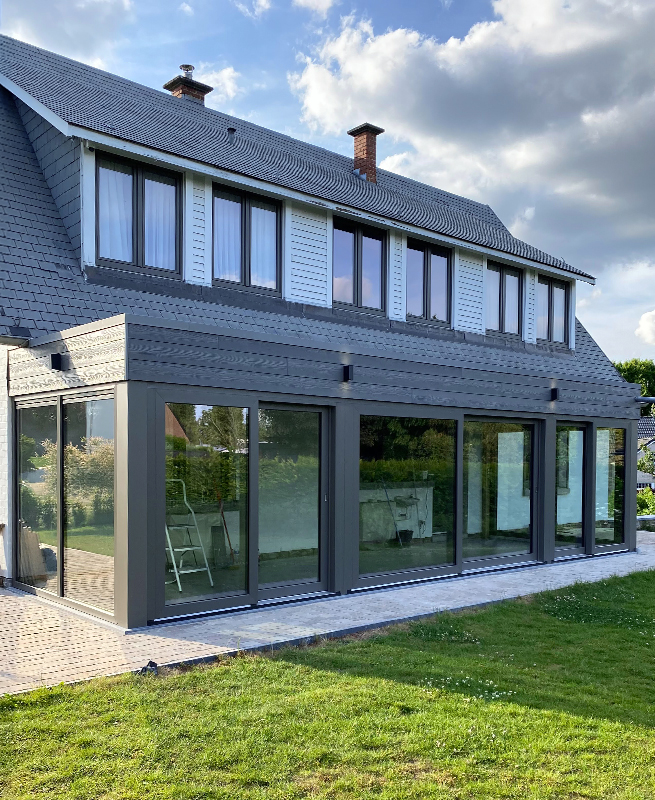 Vue sur le bâtiment à Erpent avec nouvelle façade vitrée avec porte de terrasse