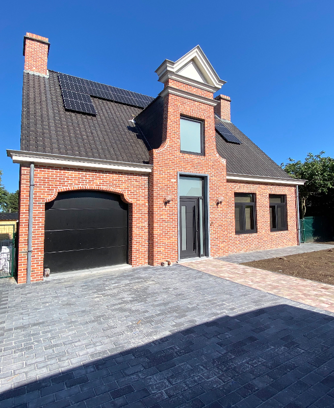 Maison à Grimbergen après l'installation de nouvelles fenêtres noires, d'une nouvelle porte d’entrée moderne et d'une nouvelle porte de garage