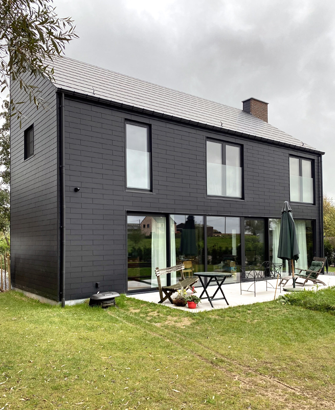 Arrière d'une nouvelle maison moderne avec de nouvelles fenêtres et une grande porte de terrasse à Hannut